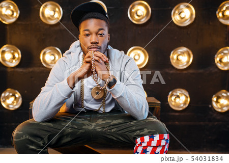 Black rapper in cap poses, perfomance on stage Black rapper in cap poses, perfomance on stage 54031834