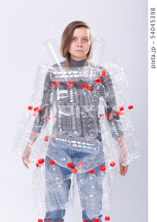 Dehydrated sick woman is standing with dress in plastic bottles. Environmental pollution problem 54045398