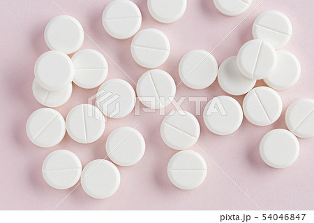 Medicinal round pills on a pink background 54046847