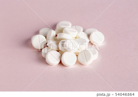 Medicinal round pills on a pink background 54046864