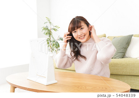 髪の毛のケアをする若い女性 髪の毛のケアをする若い女性 54048339