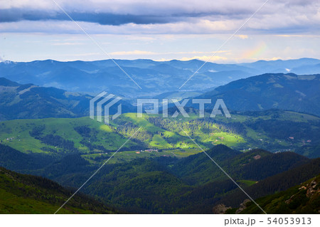 Beautiful swiss alps. Amazing mountain view with high peaks, green hills and clouds low in the 54053913