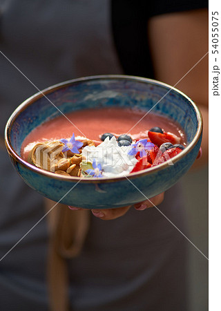 Morning breakfast in a blue plate in the hands of a waitress. fresh blueberry smoothies for 54055075