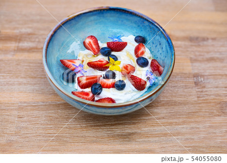 Healthy breakfast. Fresh fruit, Blueberry berries with yogurt. Morning Breakfast in a blue plate on 54055080