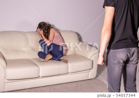 Domestic violence and abuse concept - man threatening with fist to crying woman 54057344