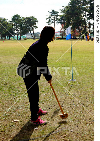 グランドゴルフでホールポストに最終打を狙う女性 54058566