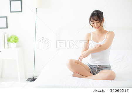 Beautiful asian woman smile apply cream or lotion 54060517