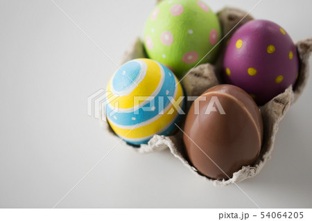 close up of chocolate and colored easter eggs close up of chocolate and colored easter eggs 54064205
