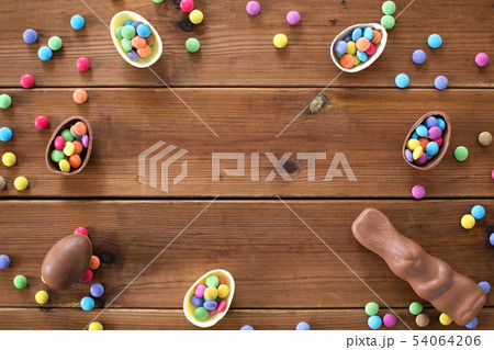 chocolate eggs, easter bunny and candies on wood 54064206