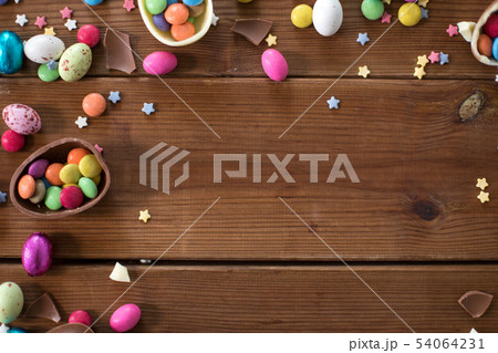 chocolate eggs and candy drops on wooden table 54064231