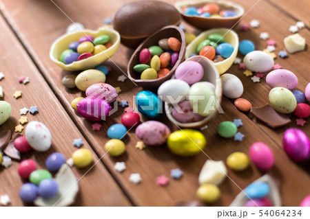 chocolate eggs and candy drops on wooden table 54064234