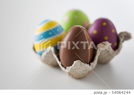 close up of chocolate and colored easter eggs close up of chocolate and colored easter eggs 54064244