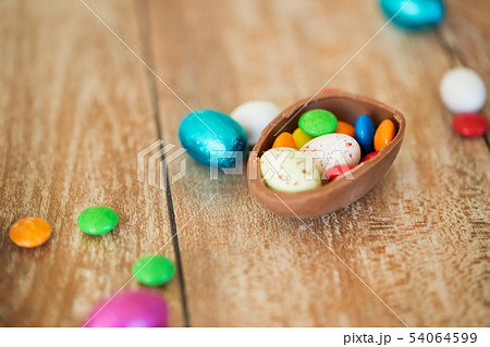 chocolate easter egg and candy drops on table chocolate easter egg and candy drops on table 54064599