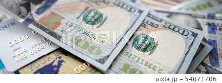 Huge amount of US banknotes lying at table among passport banking cards and financial report 54071706