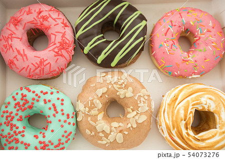 Various donuts lying in box 54073276