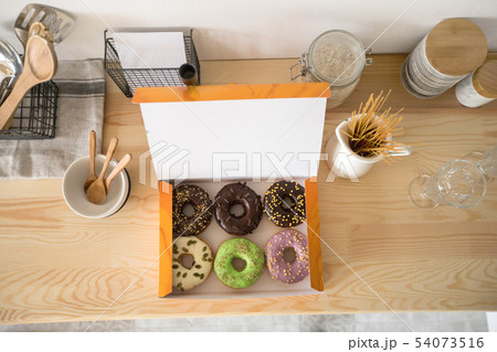 Box with doughnuts on table 54073516