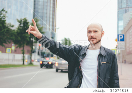Adult attractive bald bearded man catching taxi Adult attractive bald bearded man catching taxi 54074313