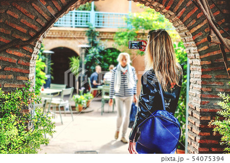 A girl with blond hair takes pictures of the 54075394
