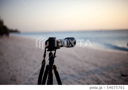 Digital camera on a tripod seashore to shoot sunse 54075701