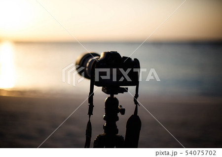 Digital camera on a tripod seashore to shoot sunse 54075702