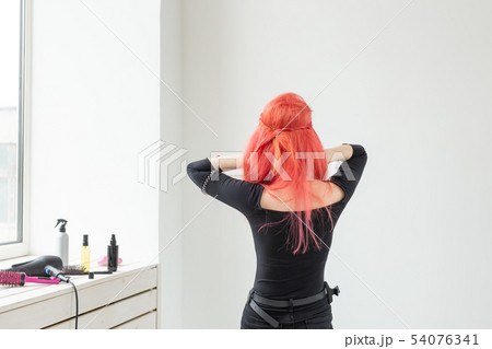 young beautiful woman combing her hair in living room young beautiful woman combing her hair in living room 54076341