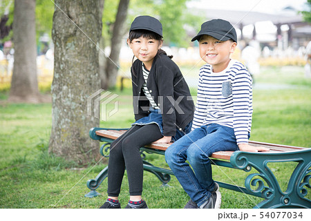 笑顔で公園のベンチに座る子供 54077034