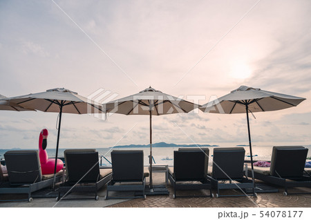 Umbrella with sunbed on infinity pool in tropical Umbrella with sunbed on infinity pool in tropical 54078177