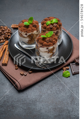 Classic tiramisu dessert in a glass on dark concrete background Classic tiramisu dessert in a glass on dark concrete background 54078428