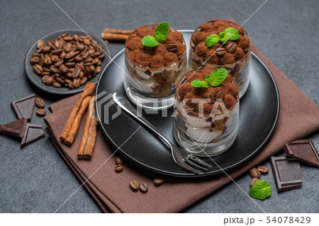 Classic tiramisu dessert in a glass on dark concrete background 54078429
