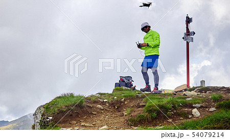 Guy tourist launches quadrocopter in the mountains 54079214