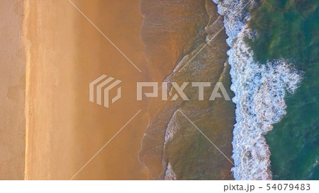 Aerial view of beach with waves rolling into the 54079483