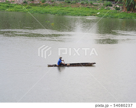 fisherman on boat fishing in lake in the morning. 54080237