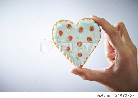 ハートのアイシングクッキーを持つ女性の手 54080757