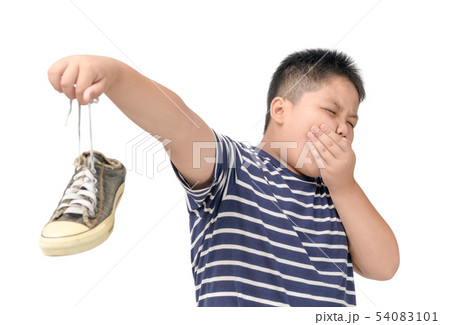 Disgusted fat boy holding a pair of smelly shoes 54083101