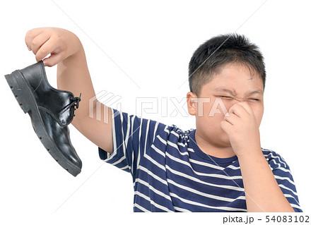 Disgusted boy holding a pair of smelly leather 54083102