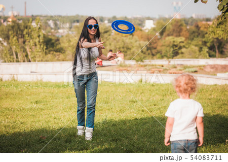 Family playing frisbee on meadow in park Family playing frisbee on meadow in park 54083711