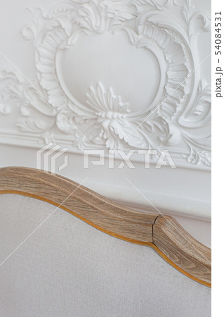 Luxurious bright Rococo interior with a large sofa and stucco on the walls. Close up. Selective 54084531