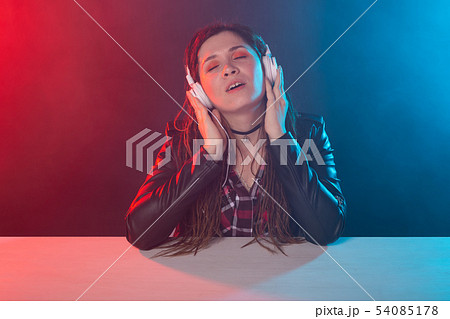 Meloman, music and people concept - young woman with dreadlocks listen to the music and enjoy it 54085178