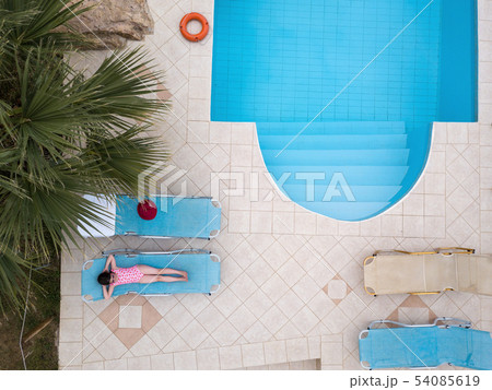 Little girl sunbathing by a swimming pool Little girl sunbathing by a swimming pool 54085619