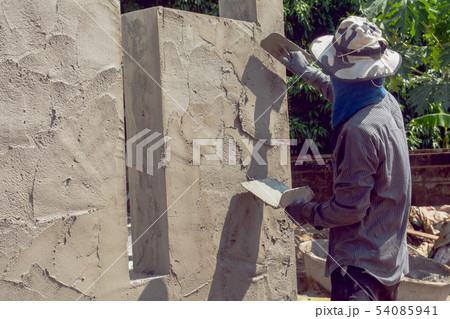 Construction workers plastering building wall Construction workers plastering building wall 54085941