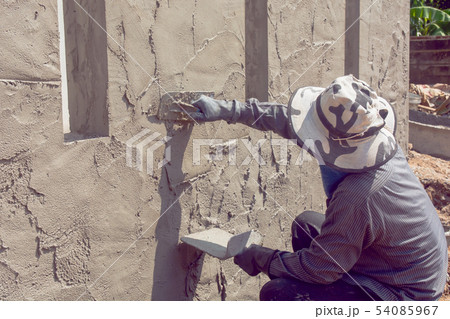 Construction workers plastering building wall Construction workers plastering building wall 54085967