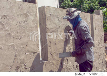 Construction workers plastering building wall Construction workers plastering building wall 54085968