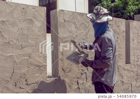 Construction workers plastering building wall Construction workers plastering building wall 54085970