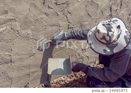 Construction workers plastering building wall Construction workers plastering building wall 54085975