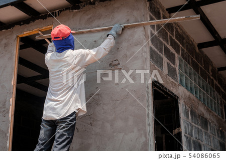Construction workers plastering building wall Construction workers plastering building wall 54086065