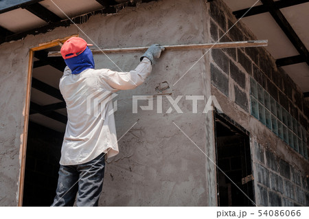 Construction workers plastering building wall Construction workers plastering building wall 54086066