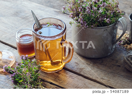 Mug of thyme healthy herbal tea and honey jar 54087189