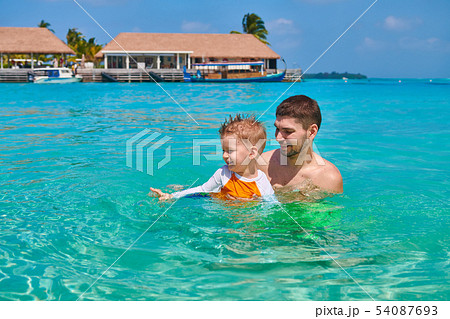 Toddler boy learns to swim with father 54087693
