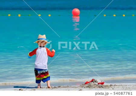 Two year old toddler playing on beach Two year old toddler playing on beach 54087761