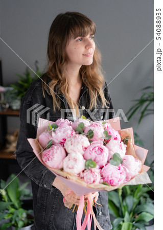 Pink peonies in womans hands. Beautiful peony flower for catalog or online store. Floral shop 54088935